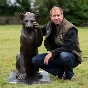 Dan Richardson with a bronze lion sculpture