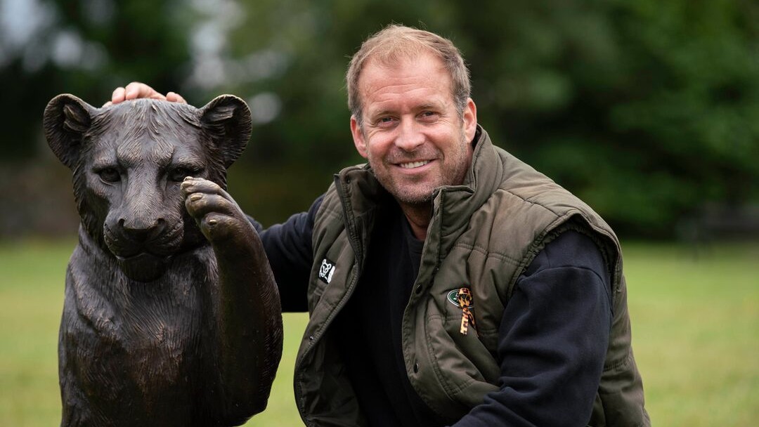 Dan Richardson with a bronze lion statue