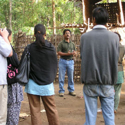 Kishor Rithe speaking to a group of people in the field