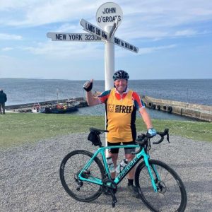 Mark Quince with his bike at John O'Groats signpost.