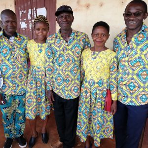 Three men and two women stand together in traditional patterned clothes