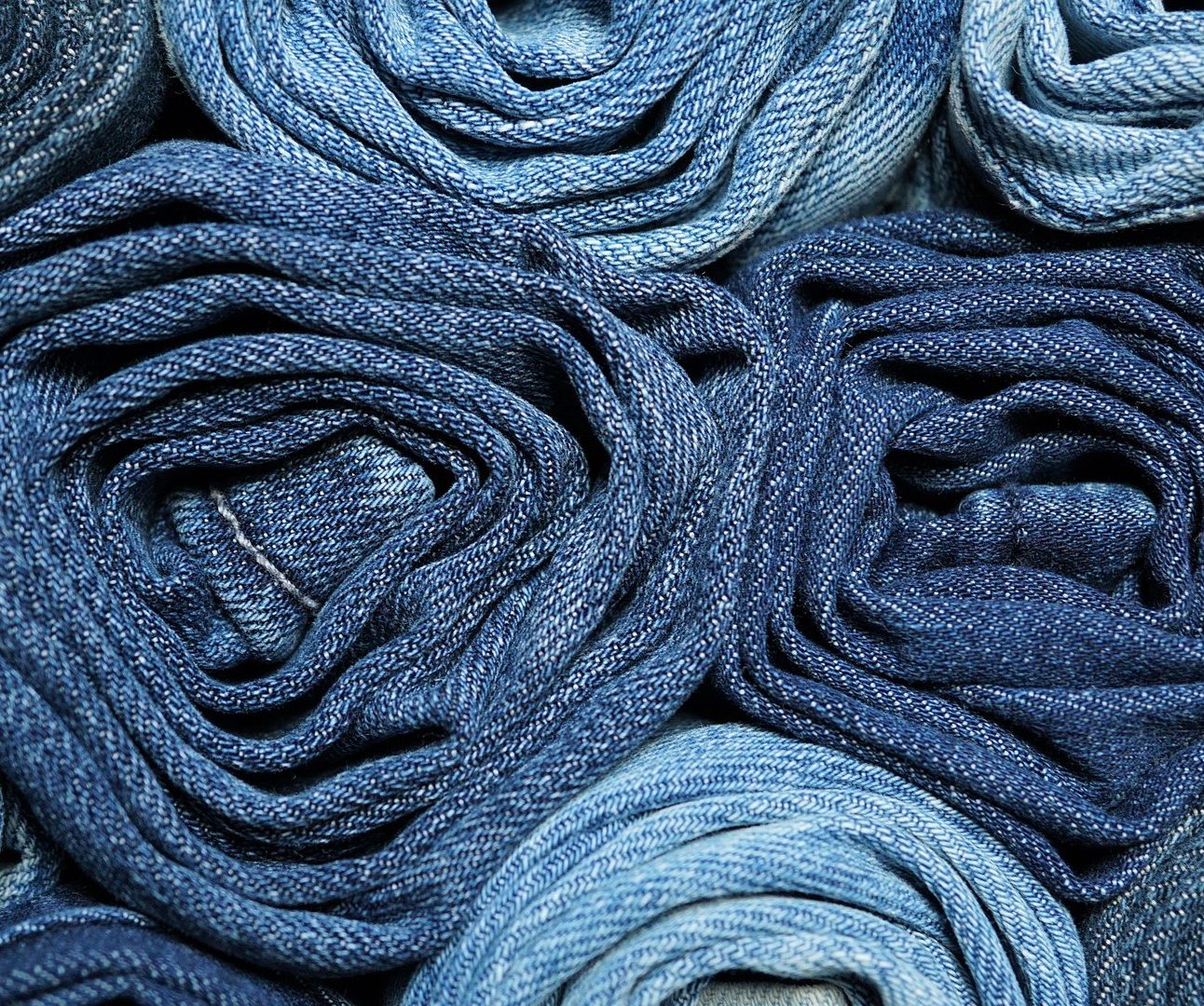 An image showing a pile of denim jeans