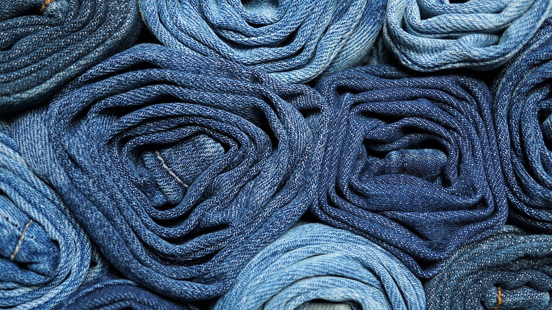 An image showing a pile of denim jeans
