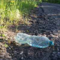 A plastic bottle dumped next to a road