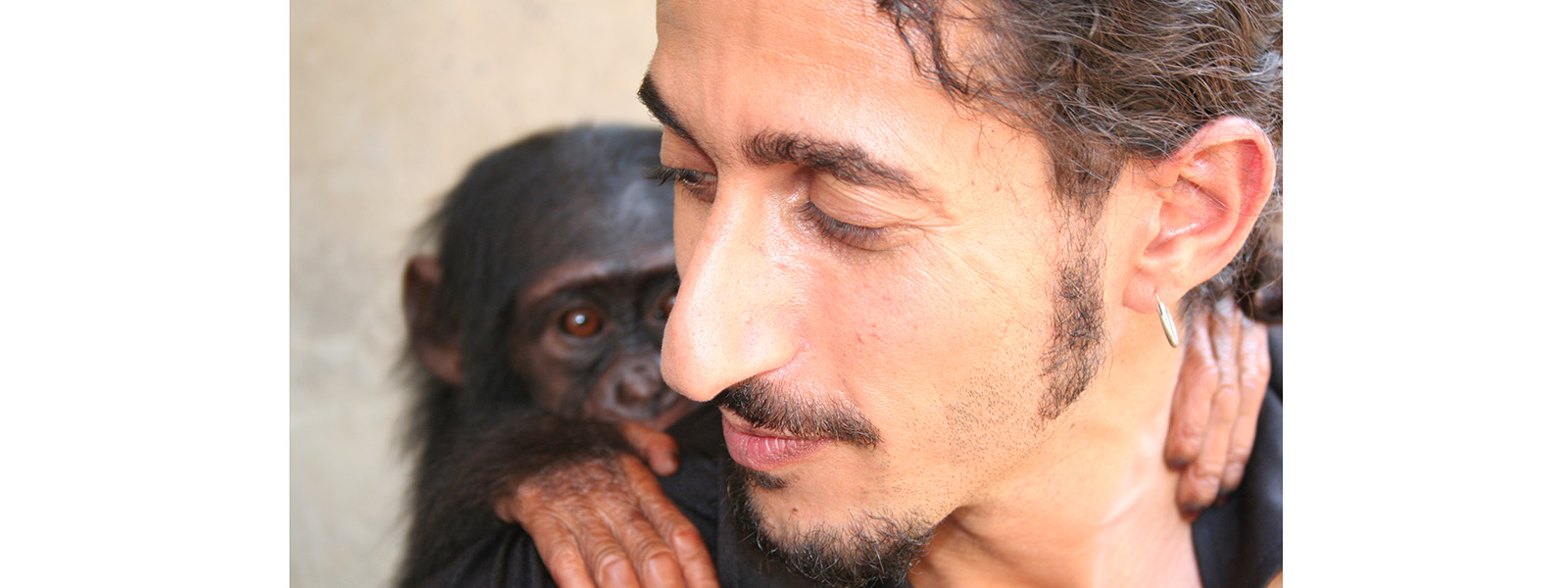 A close up of Ofir Drori turning sideways with a gorilla on his back
