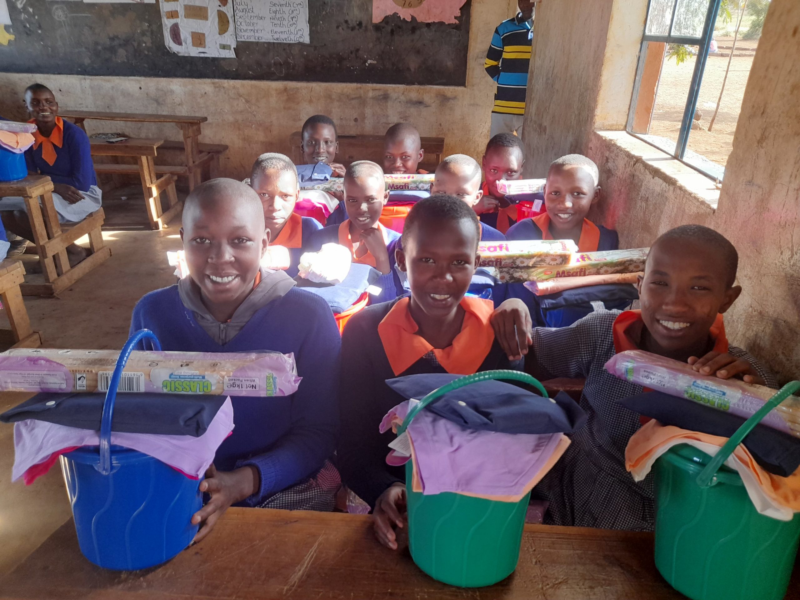 A school class in Kenya engaging in conservation, with gifts and items such as sanitary pads.
