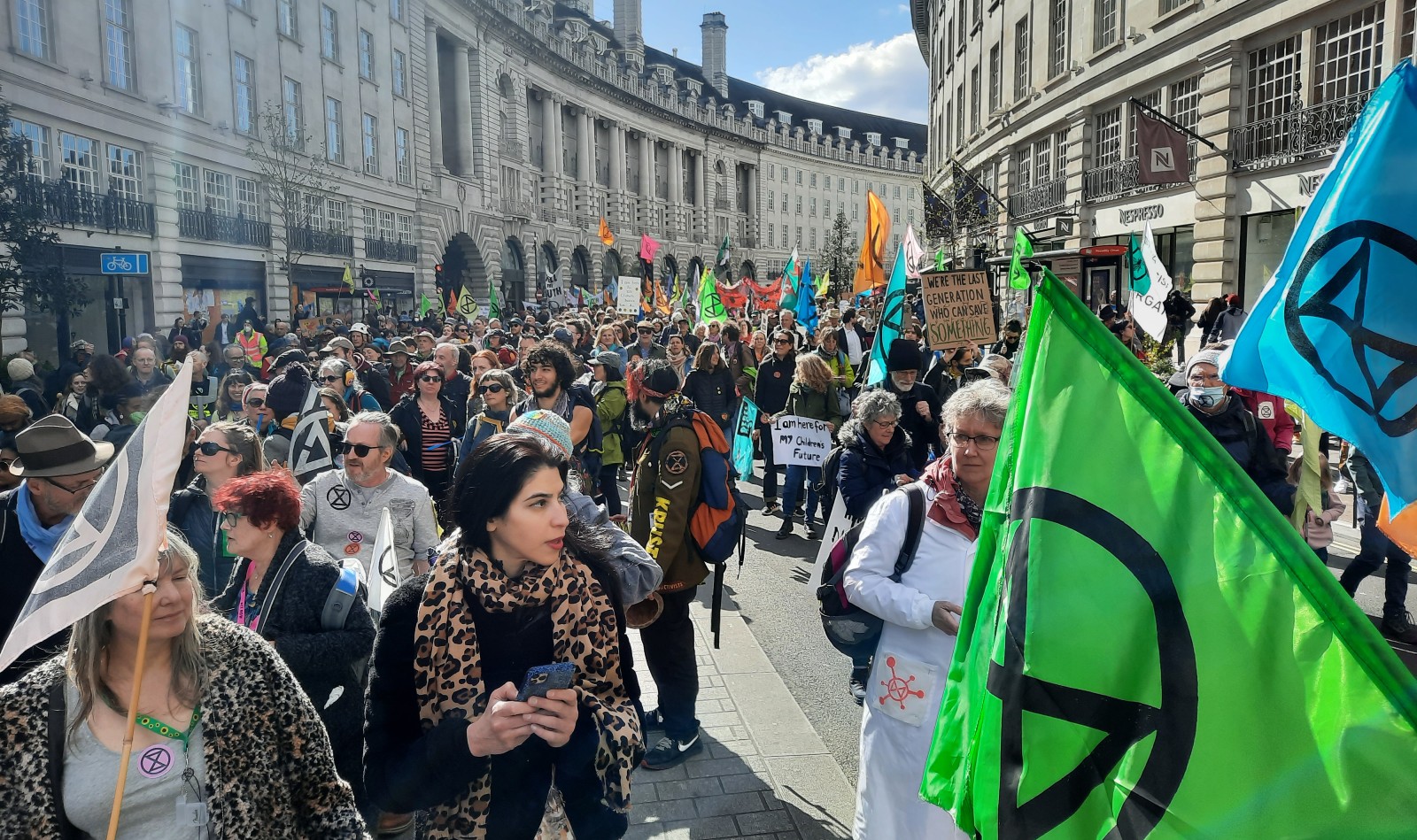 A photo of a London street full of Extinction Rebellion protesters with placards and flags