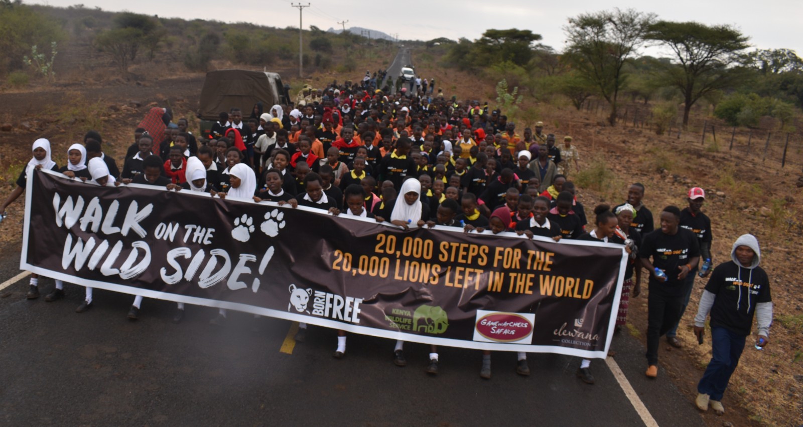 A group of hundreds of people marching with a Born Free banner