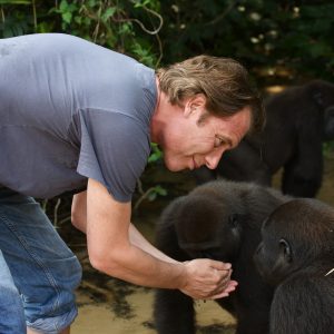 Damian Aspinall, bending over in front of a gorilla