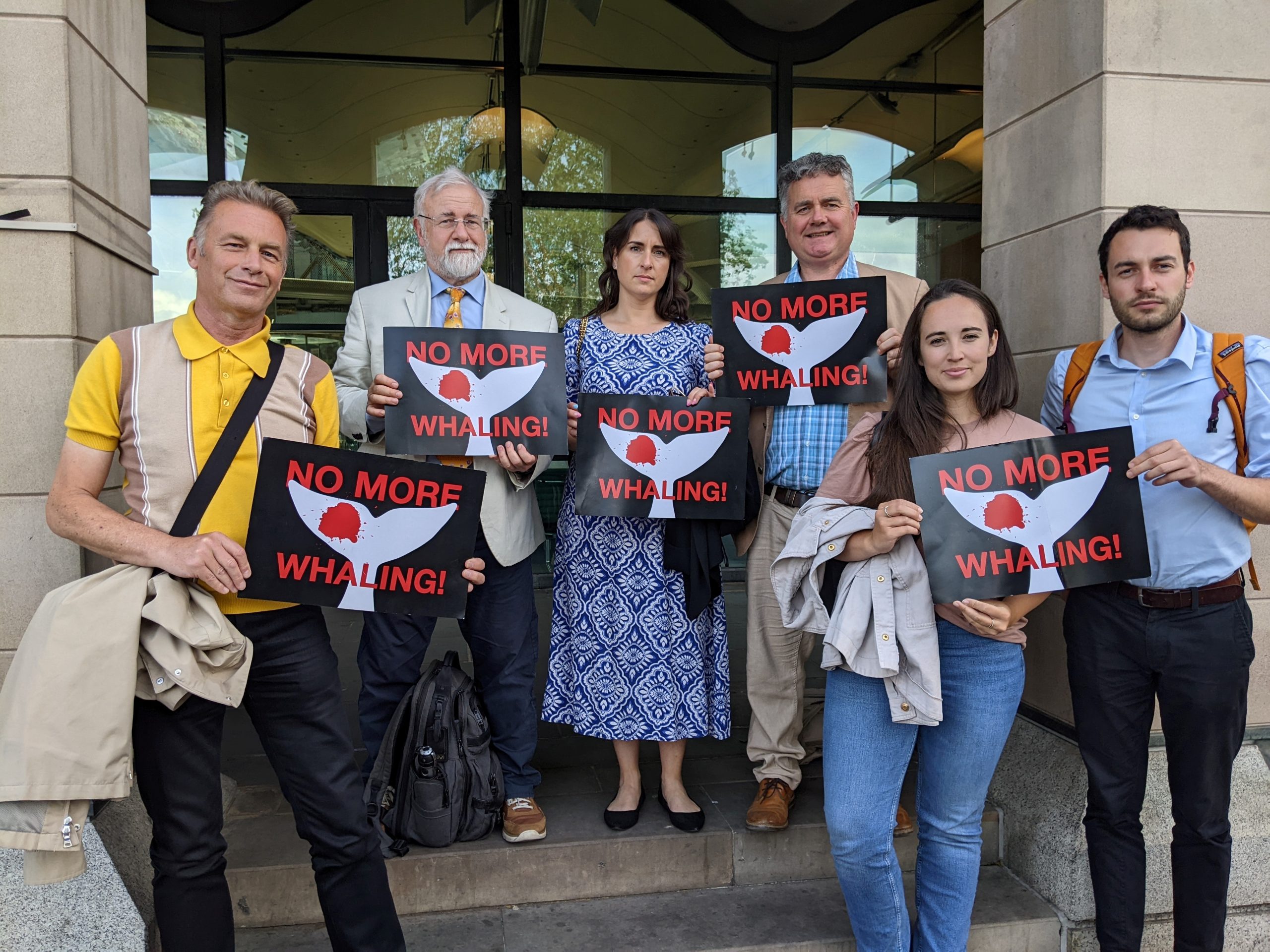 Chris Packham, Mark Simmonds, Lucey Babey, Dominic Dyer, Megan McCubbin, and Matt Dawson holding 'No More Whaling' signs