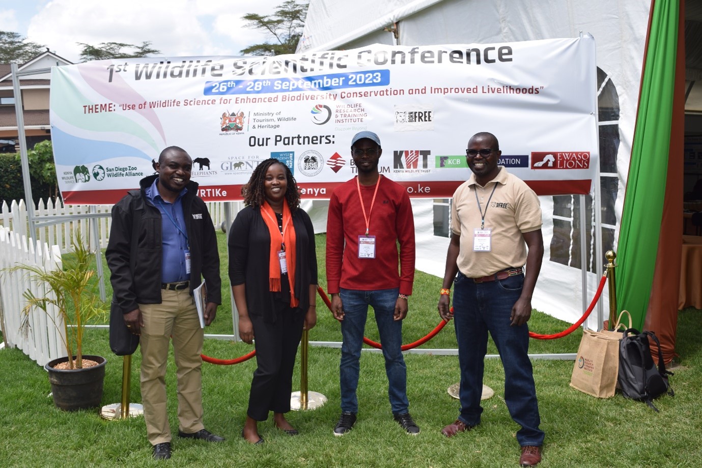 A group of people standing in front of a banner at a conference