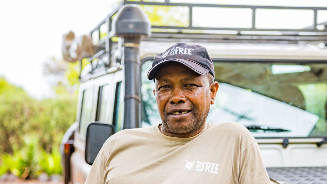 Born Free driver Martin Nduru stood in front of a car