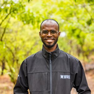 Portrait photo of Newton Simiyu smiling at the camera in Born Free jacket