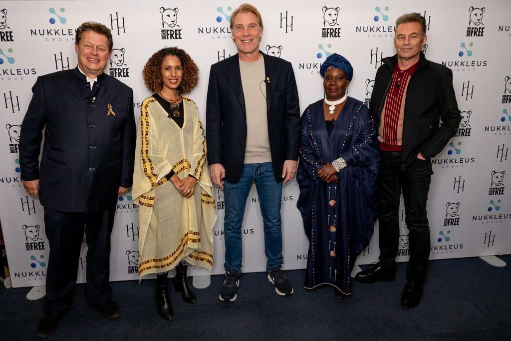 L-R Will Travers, Greta Iori, Damian Aspinall, Winnie Kiiru, Chris Packham, stood in front of a Born Free logo board