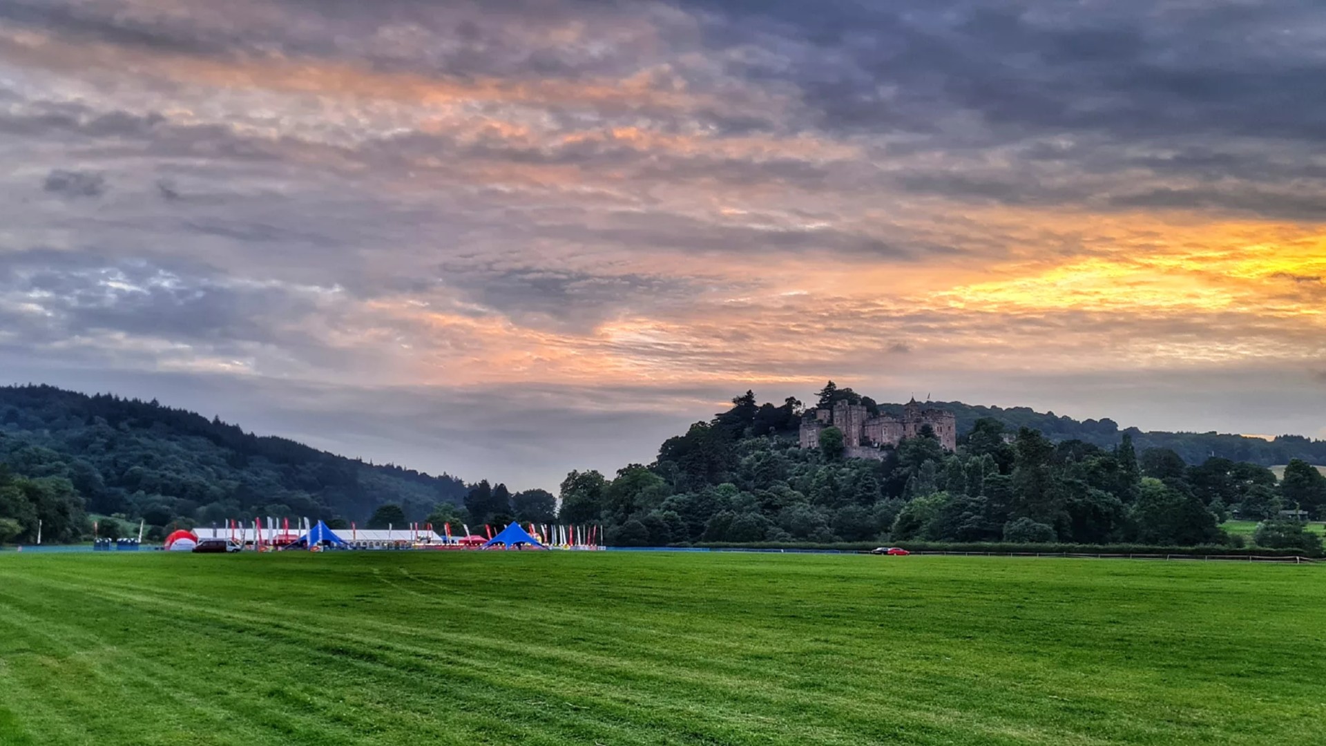 A stunning sunset behind a castle on a hill, and a running finishing line for an event