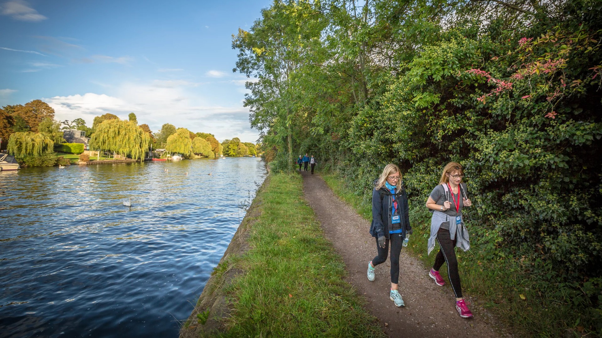 Two woman taking part in a charity walk along a riverbank