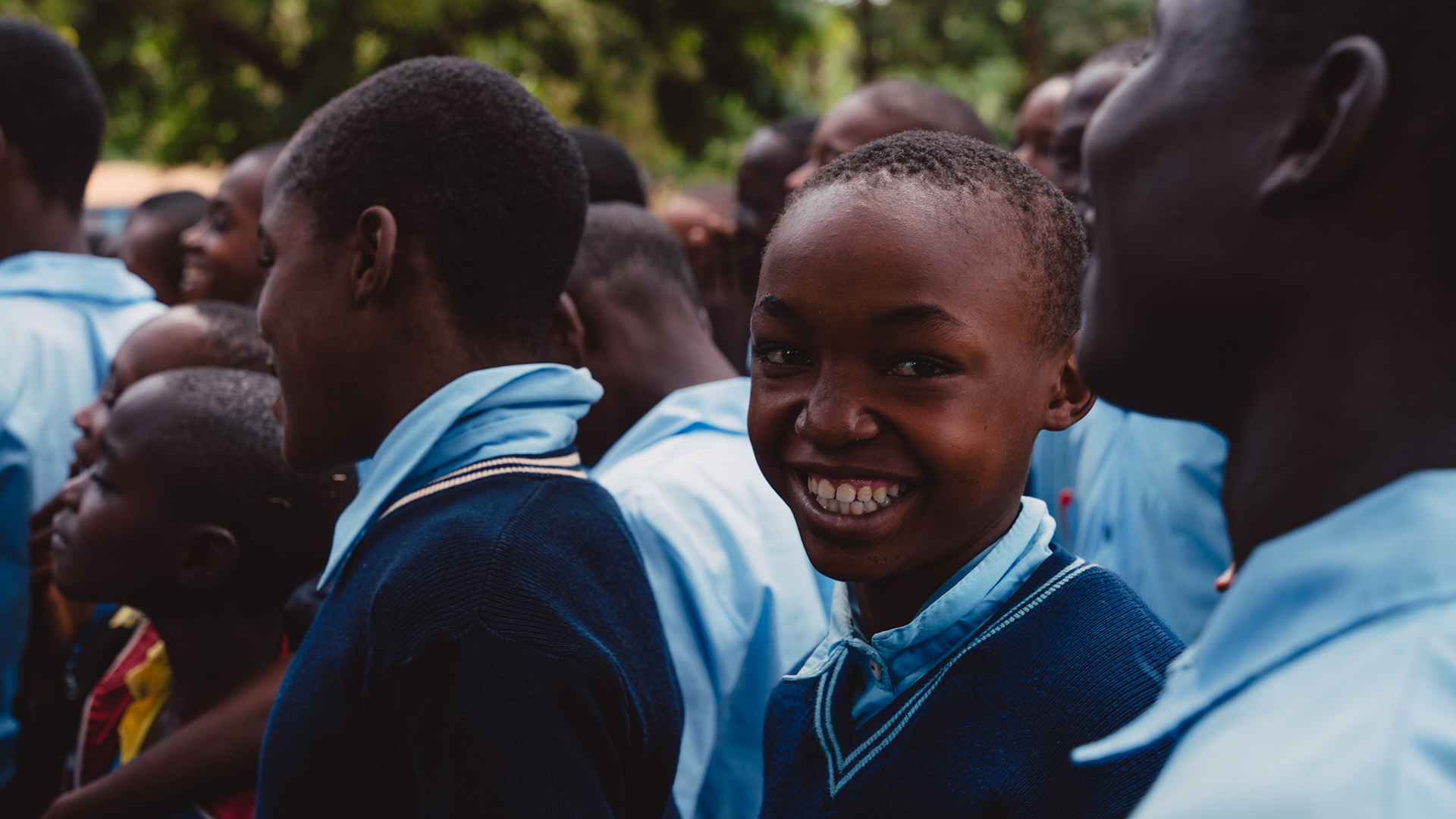 Close up of a smiling Kenyan school boy in blue uniform