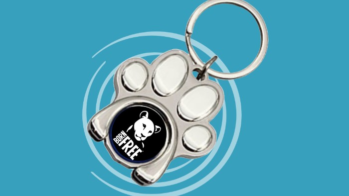 A keyring in the shape of a paw print with the Born Free logo in the centre
