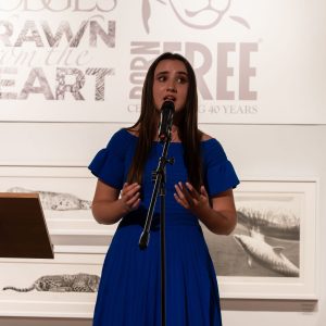 Singer Katie Marshall in a blue dress performing at Drawn from the Heart