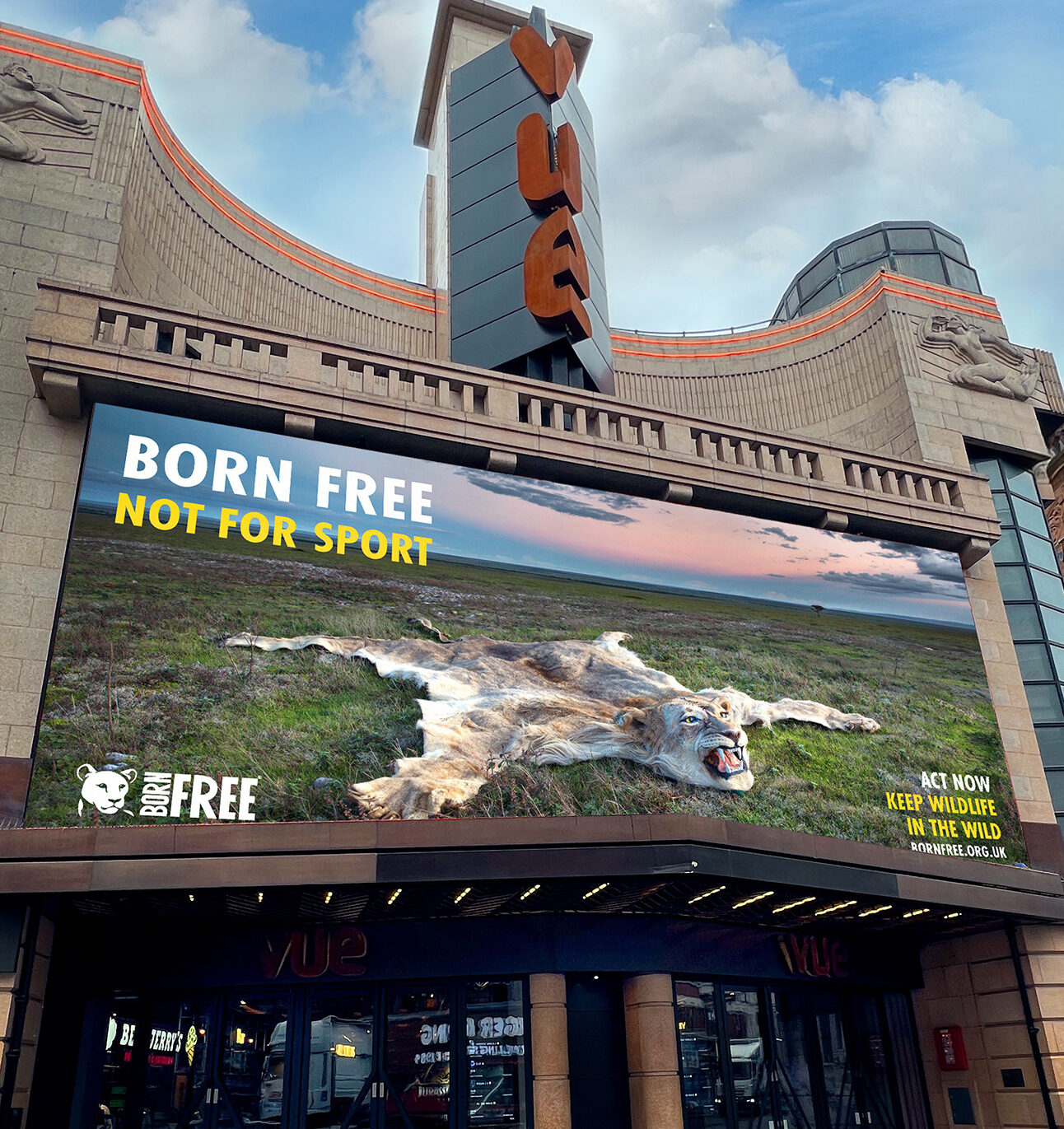 An image of a lion skin laid out as a rug, on a large advertising screen on the front of the Vue cinema at Leicester Square