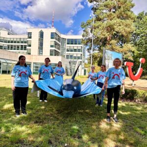A grou pof protestors outside TUI HQ, carrying in inflatable orca whale on a blue sheet