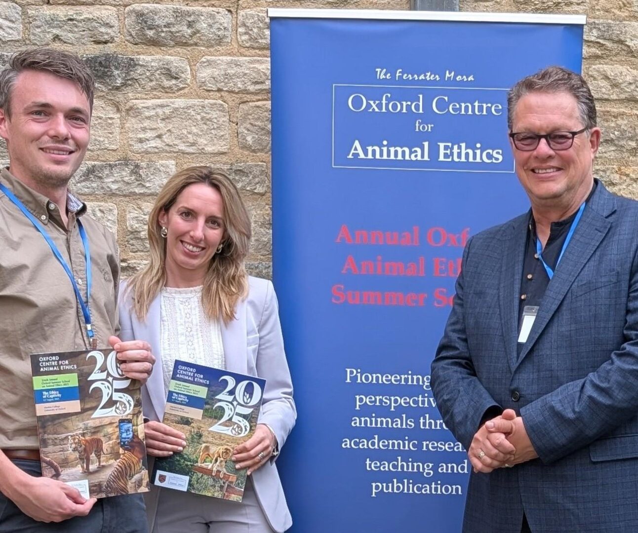 Chris Lewis, Adeline Lerambert and Will Travers standing together in front of a banner