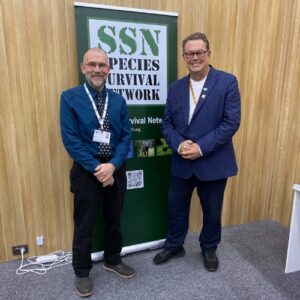 Will Travers and Mark Jones standing in front of an SSN banner at CITES CoP20