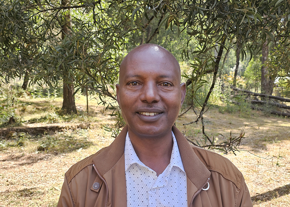 A head and shoulders photo of Sebsibe Yilma in front of a forested background