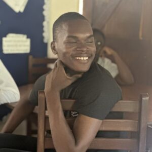 A photo of Titus smiling in a classroom setting