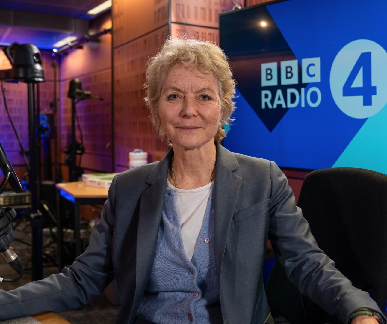 A photo of Jenny Seagrove sitting on a chair at the BBC Radio 4 studio, with microphones visible.