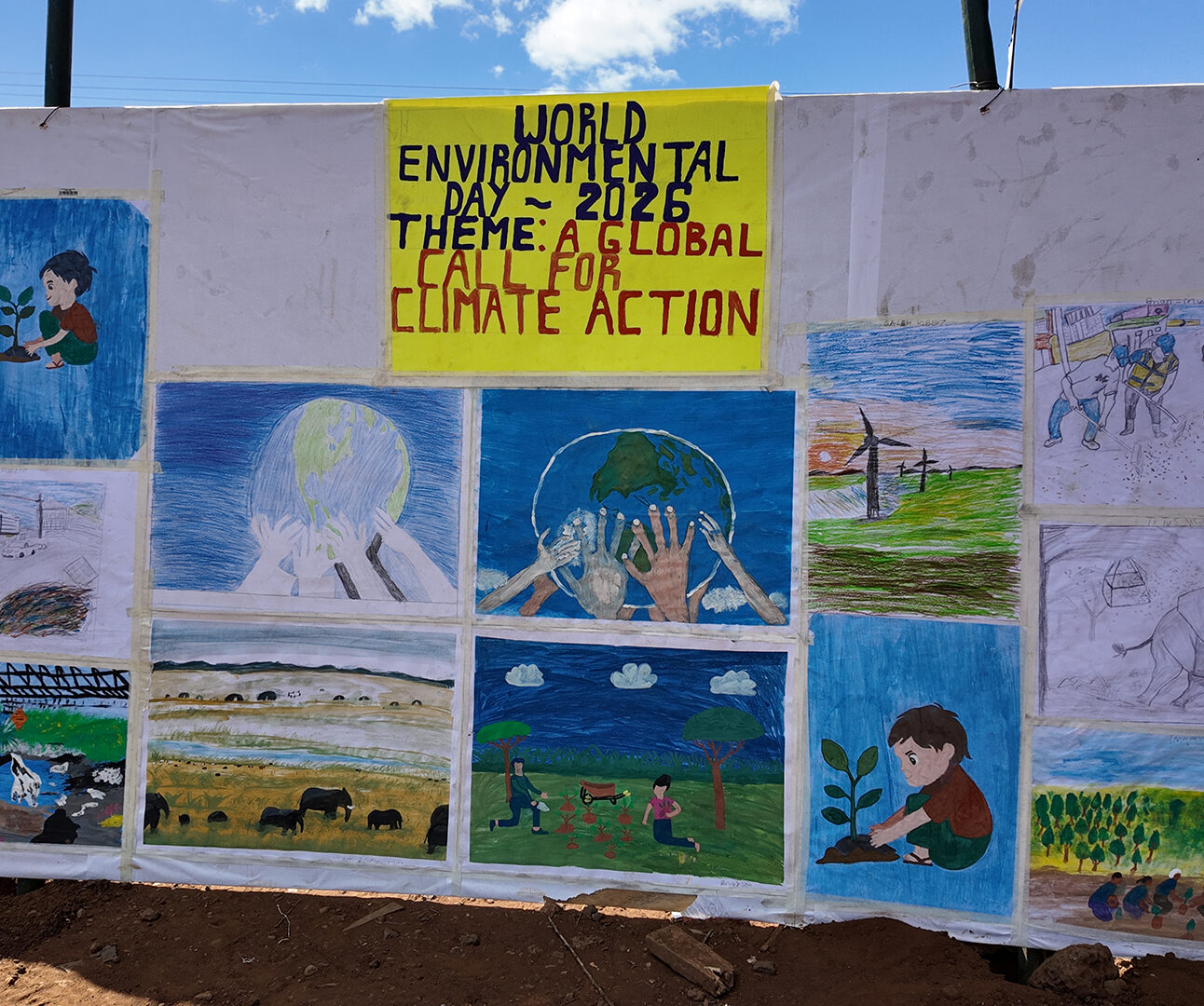 A large board displays hand-drawn posters relating to climate action