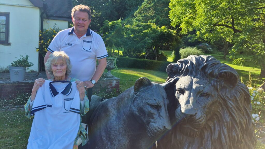 Will Travers OBE and Dame Virginia McKenna modelling mock-up England football shirts with the three lions removed from the badge