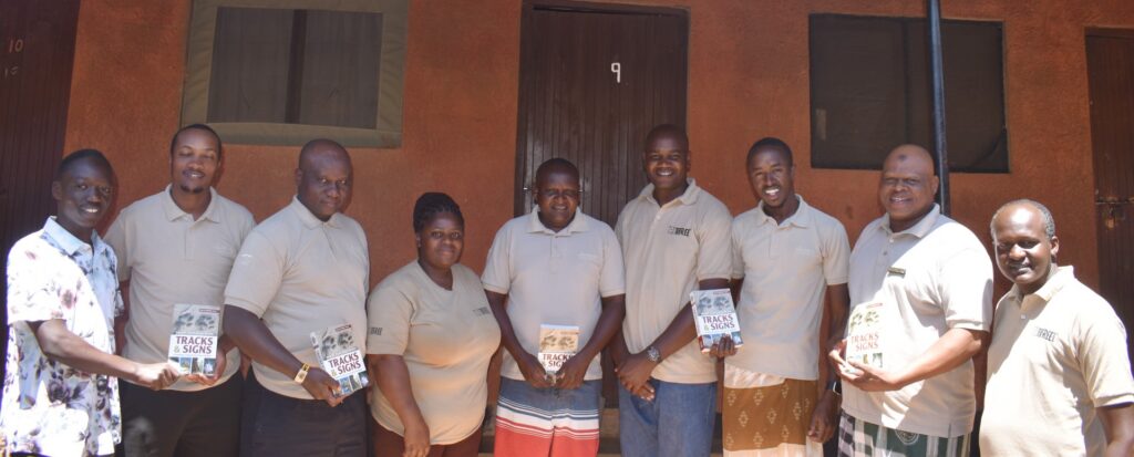 A group of people holding books about how to track lions