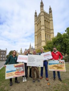 A group of people posing outside the Houses of Parliament