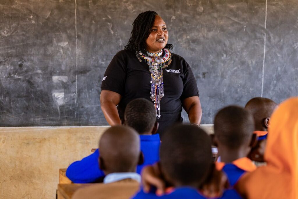 A woman standing in front of a class of school chindren in Kenya